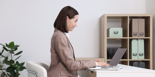 Woman working at her desk, sitting upright with relaxed shoulders
